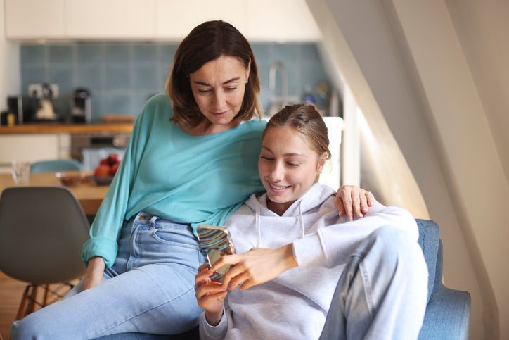 Elderly person smiling, playing with colorful toys with a therapist in a therapy room.