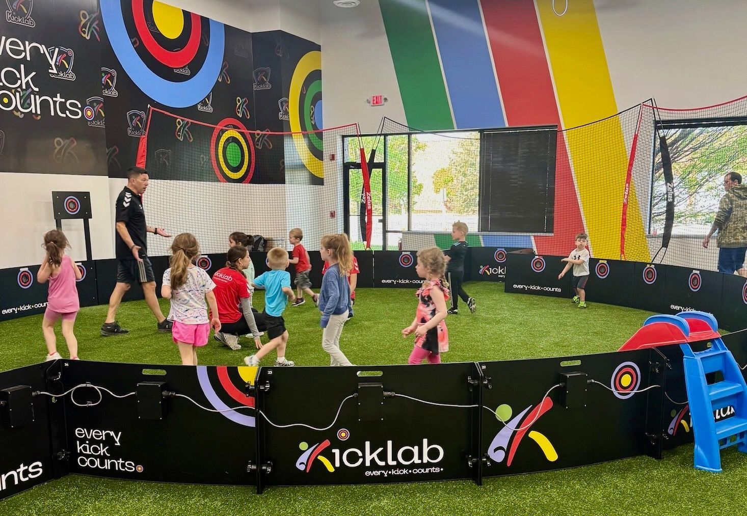 A group of children are playing in a soccer field.