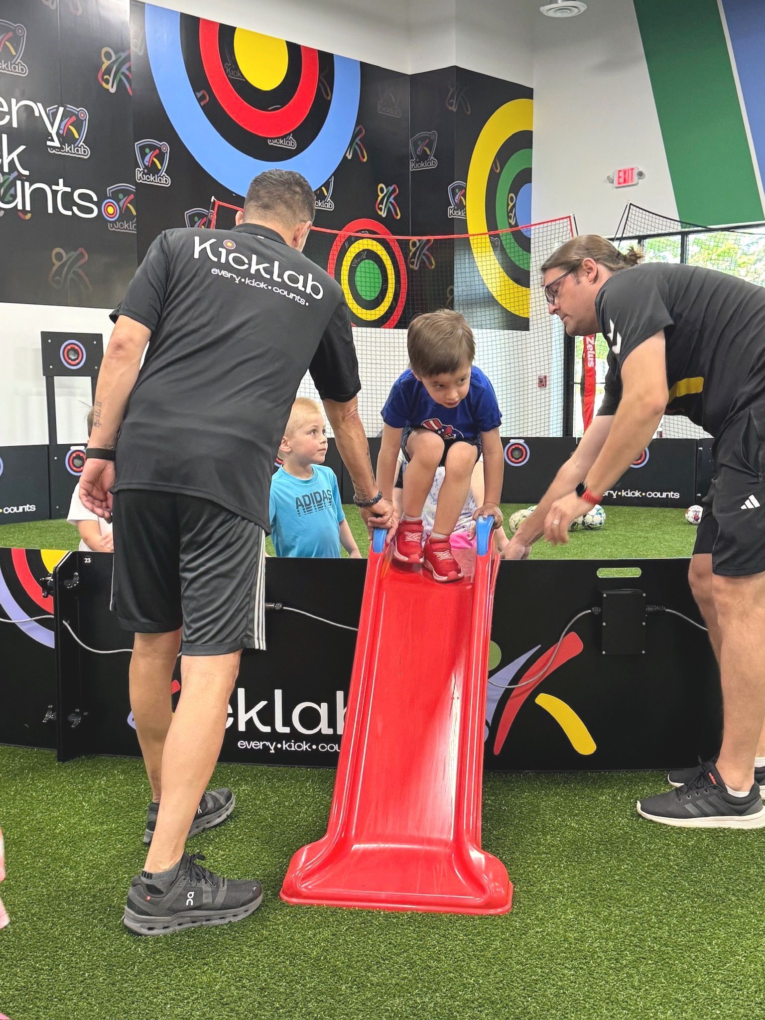 A group of people are playing on a red slide.