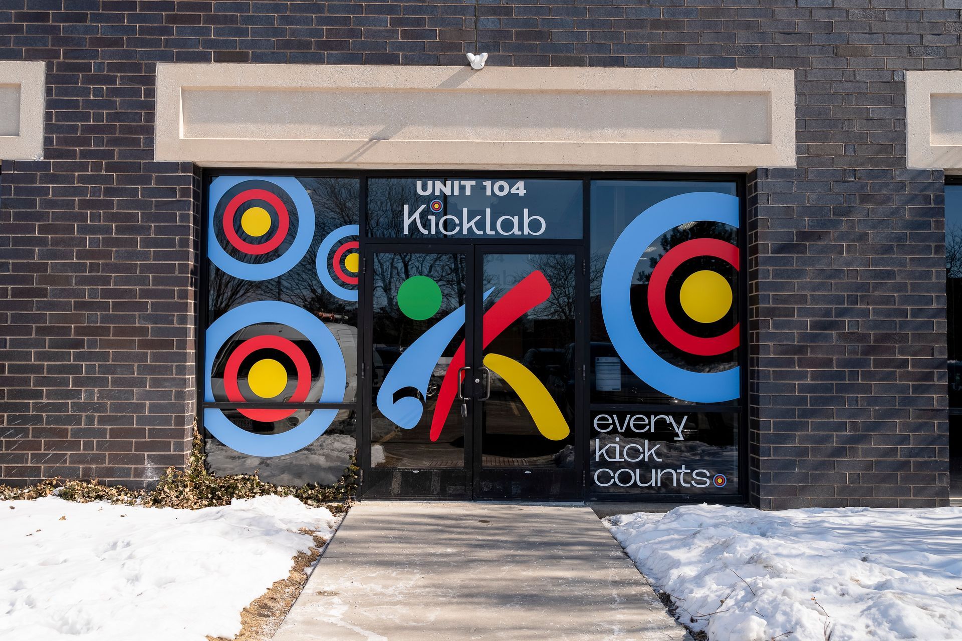 A brick building with a sign that says unit 104 kicklab