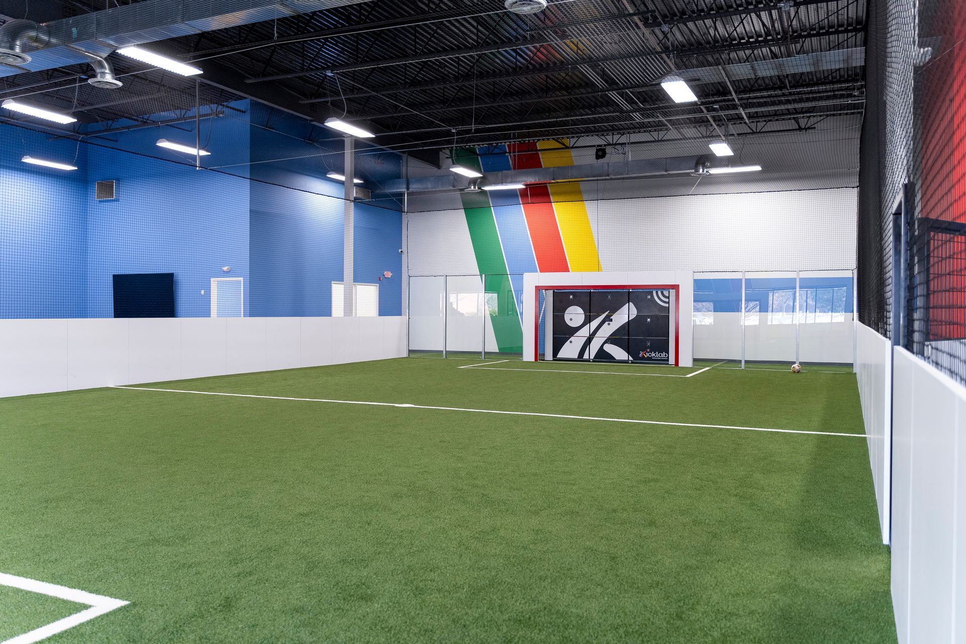 A large indoor soccer field with a goal in the middle of it.