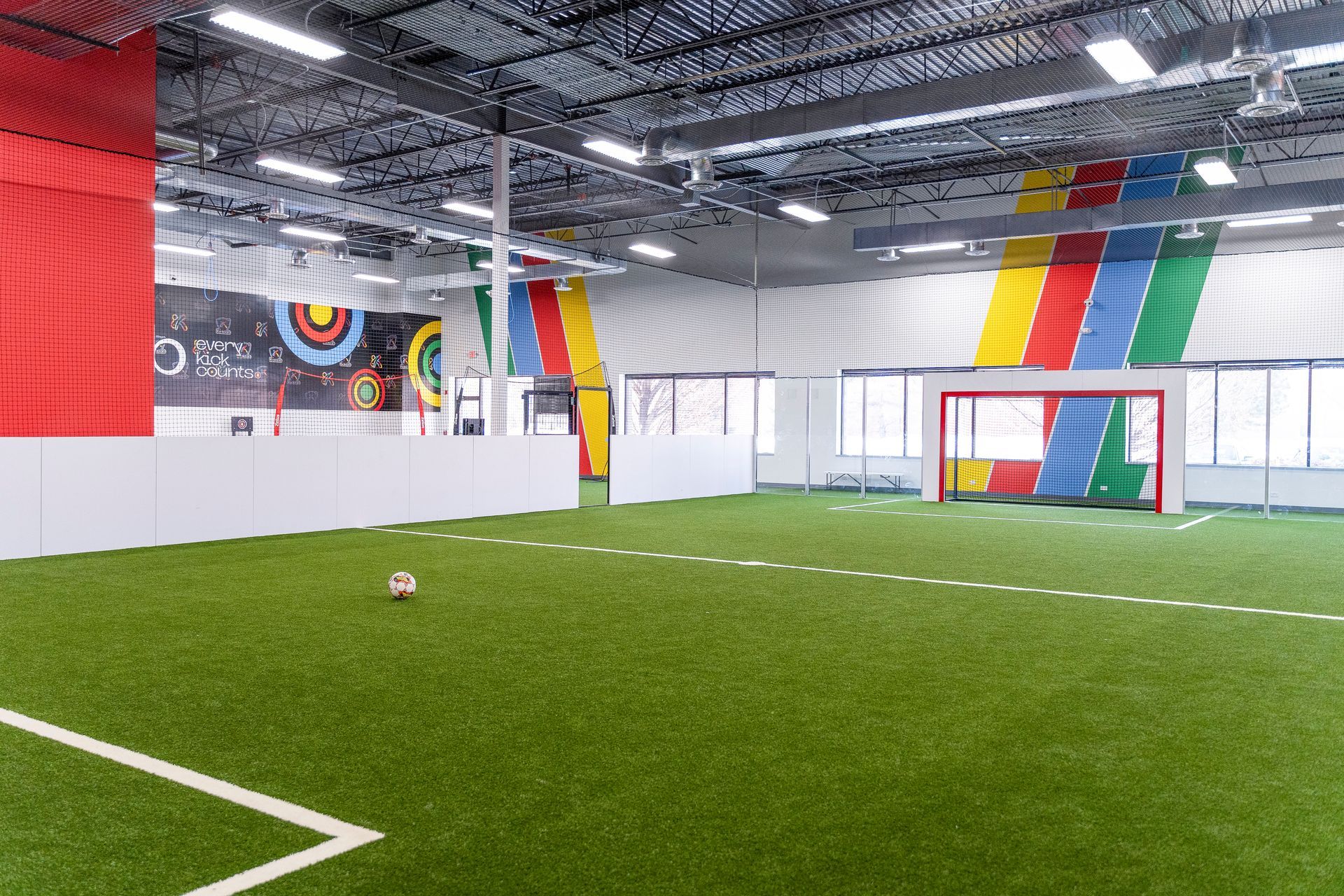 There is a soccer ball on the field in the middle of the room.