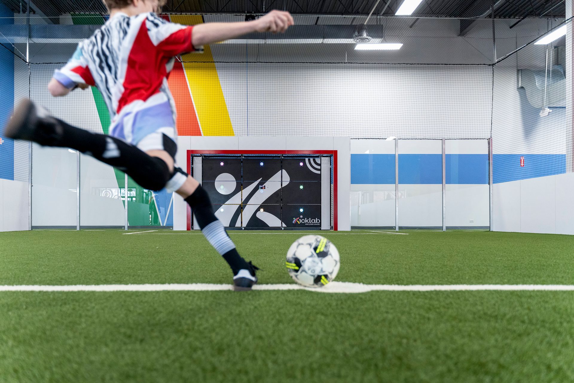A person is kicking a soccer ball on a field.