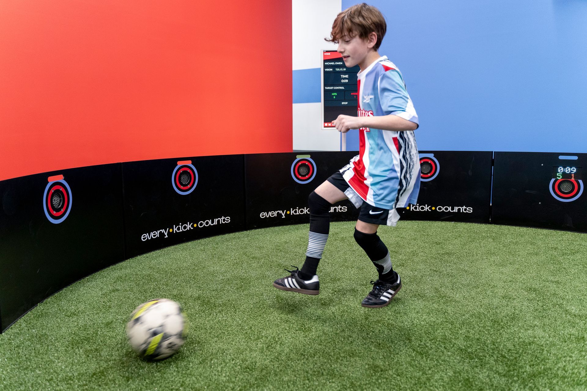 A young boy is kicking a soccer ball on a field.
