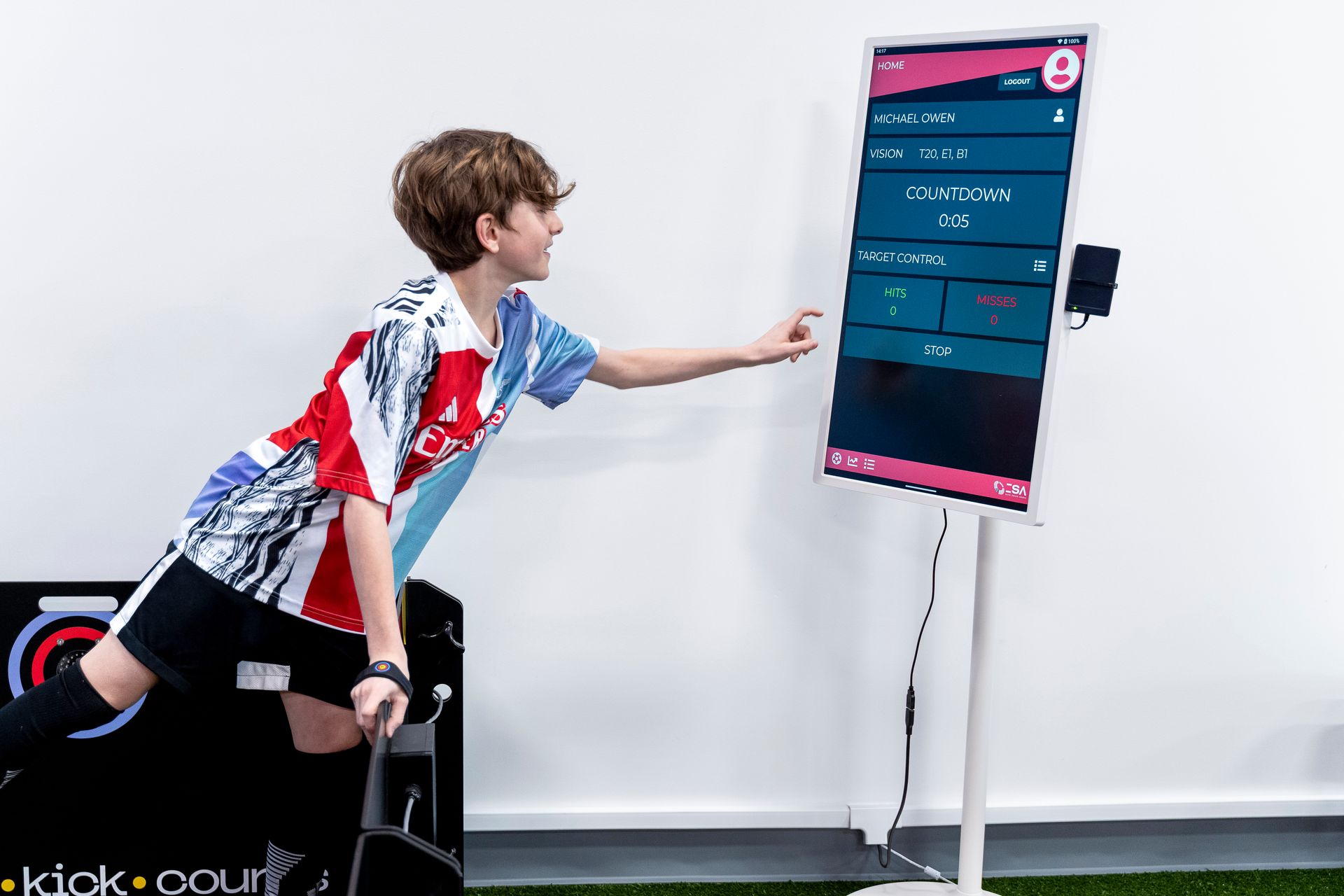 A young boy is standing in front of a large screen.
