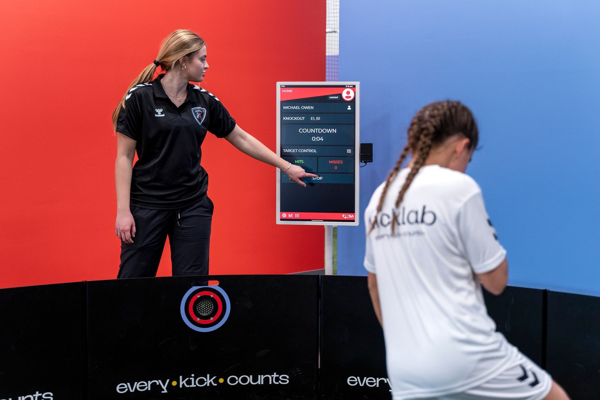 A woman in a black shirt is talking to a girl in a white shirt.