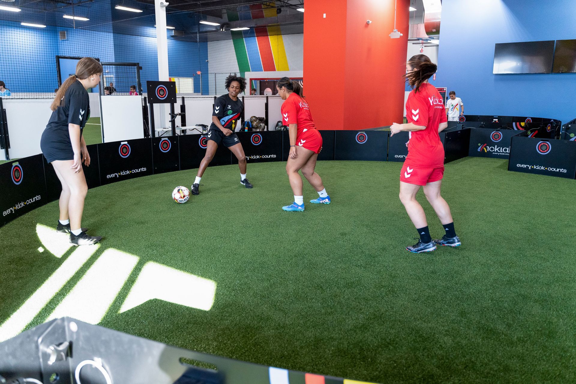 A group of people are playing soccer in a gym.