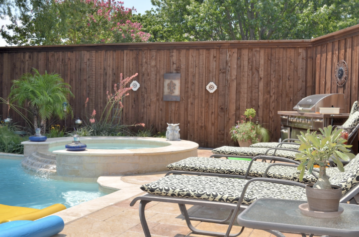 Capped wood privacy fence around pool.