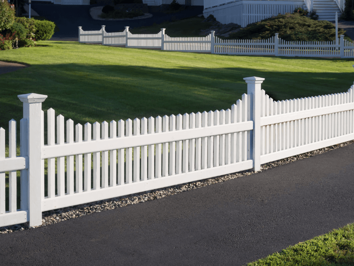 White vinyl picket fence frames front yard of Wake Forest home.