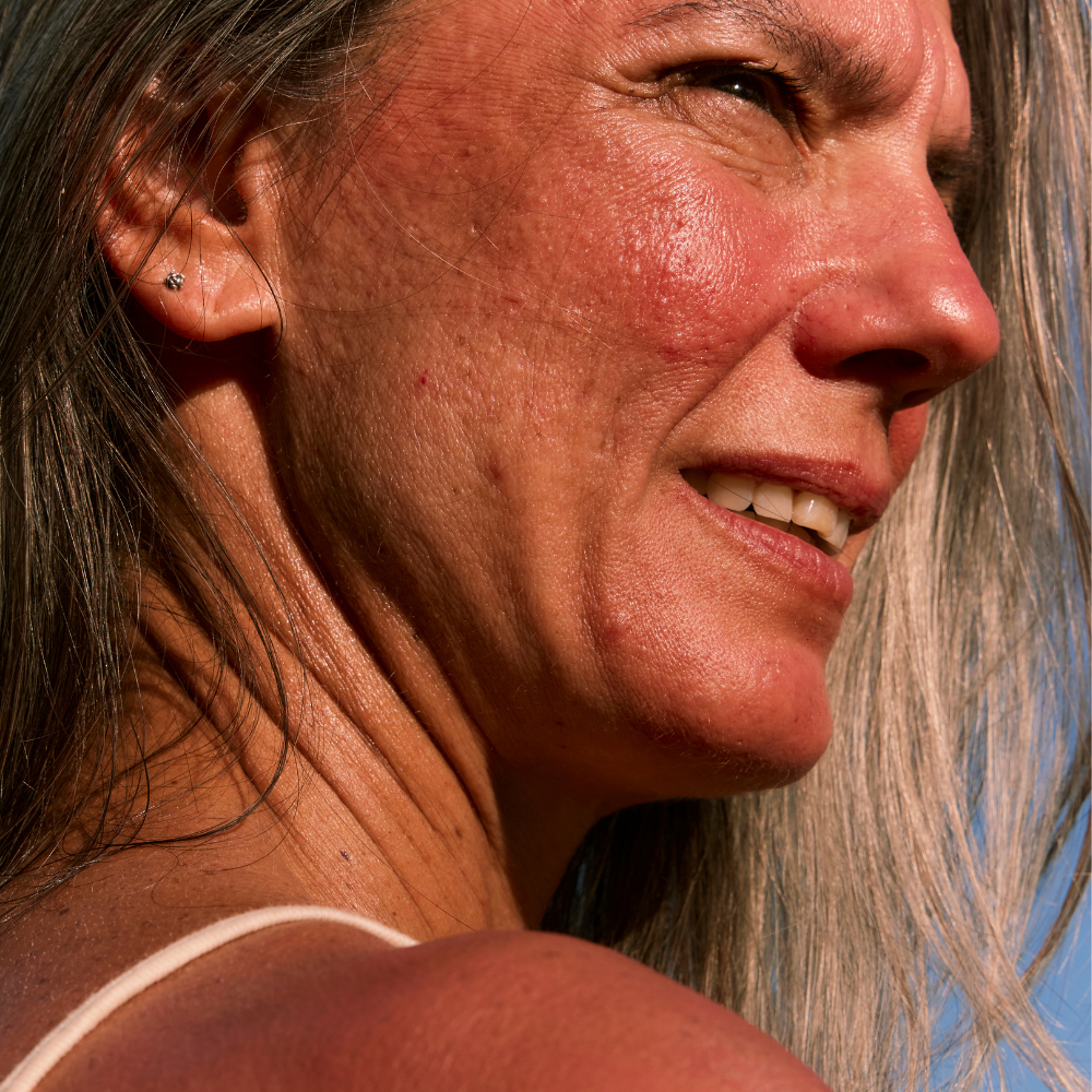 Person applying foundation to chest, concealing scars and blemishes with a dropper.