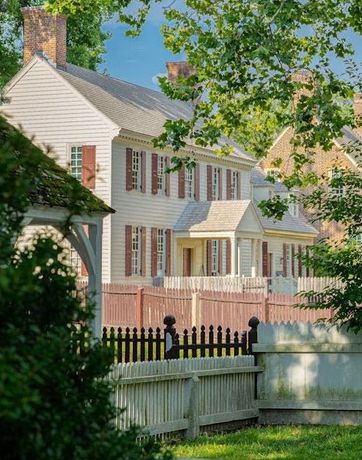 A white house with a wooden fence in front of it