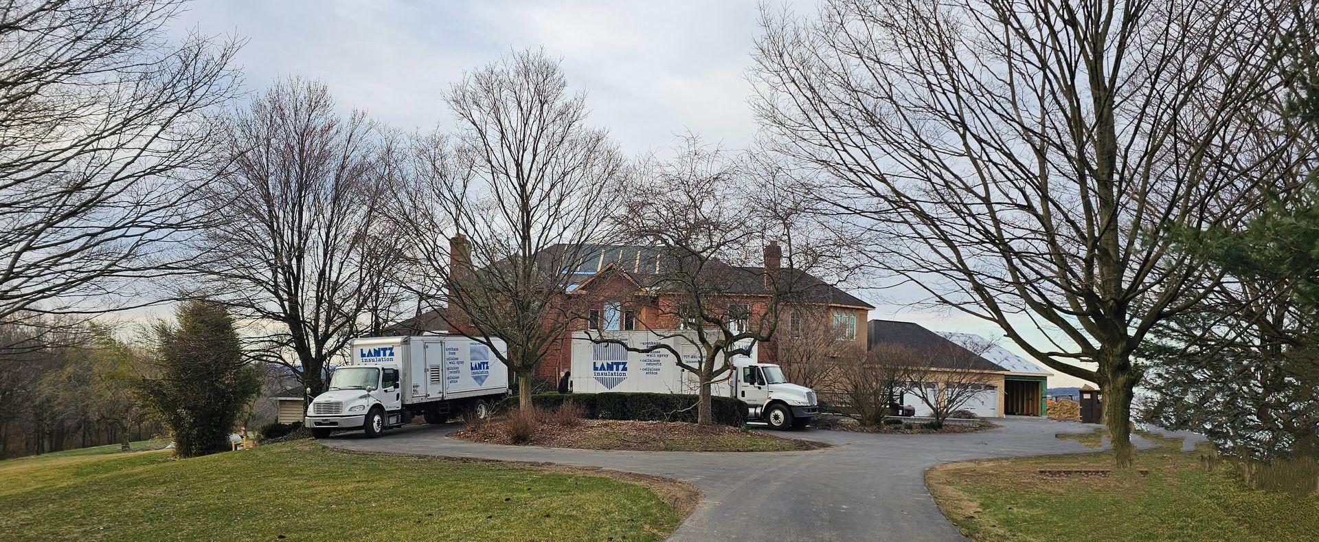 a couple of trucks are parked in front of a house .