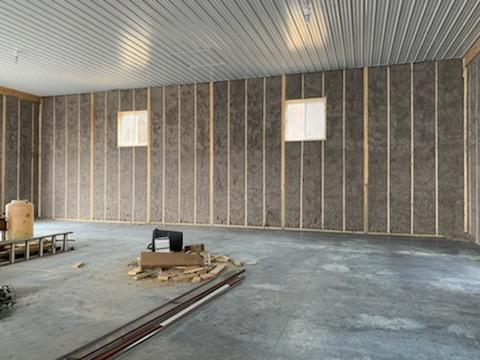 A large empty room with a concrete floor and a metal ceiling.
