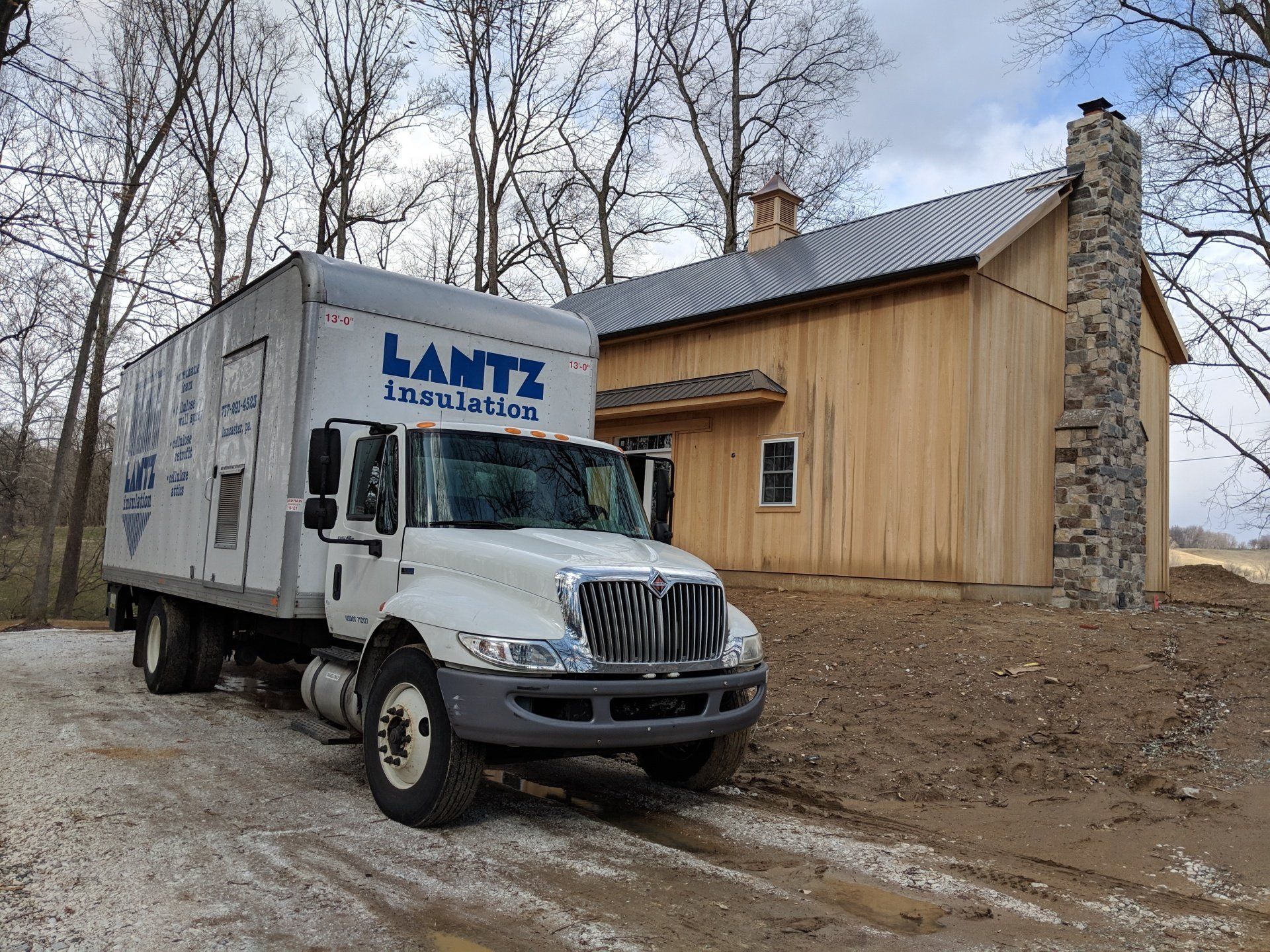 a sign for lantz insulation inc. hangs above a wooden table