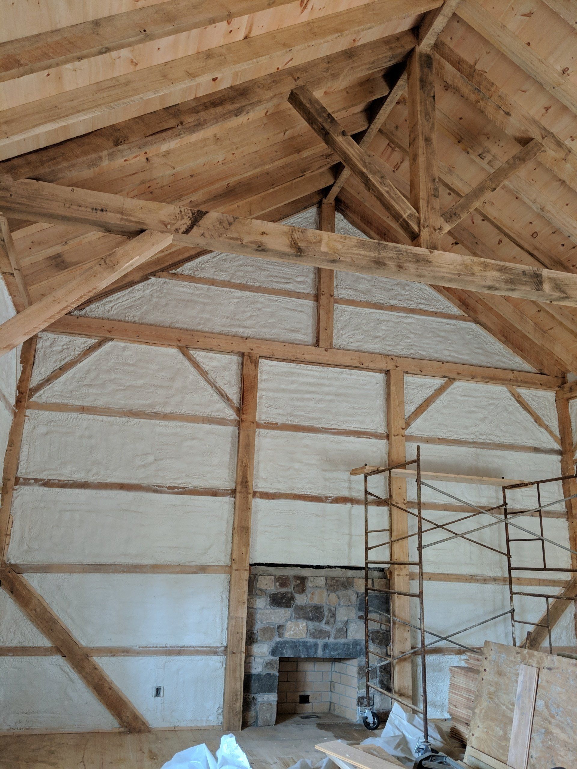 A large room with wooden beams and a fireplace.