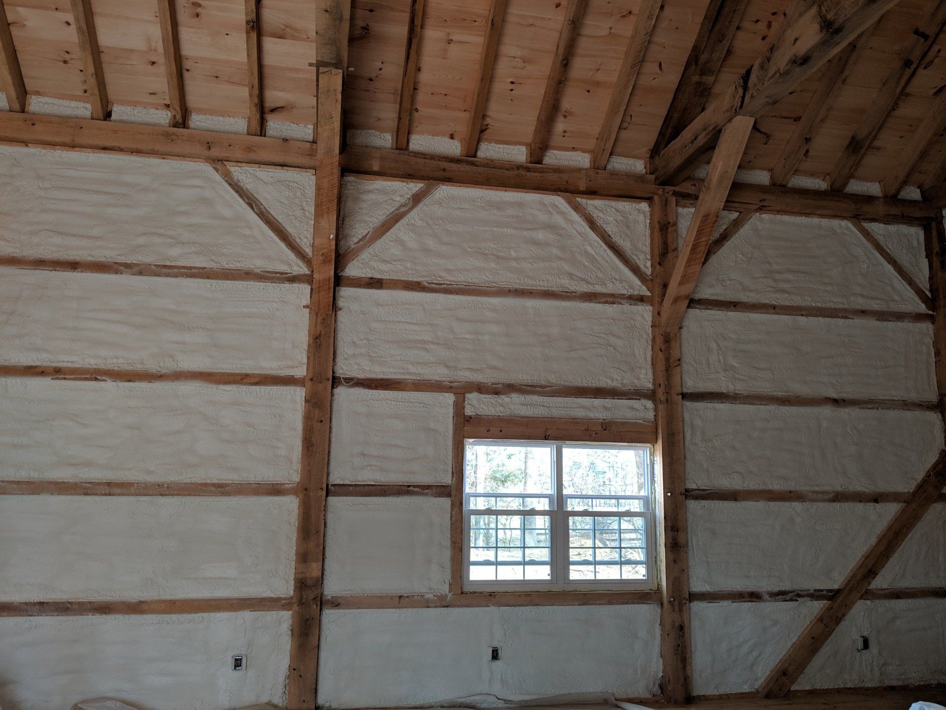 The inside of a barn with foam on the walls and a window