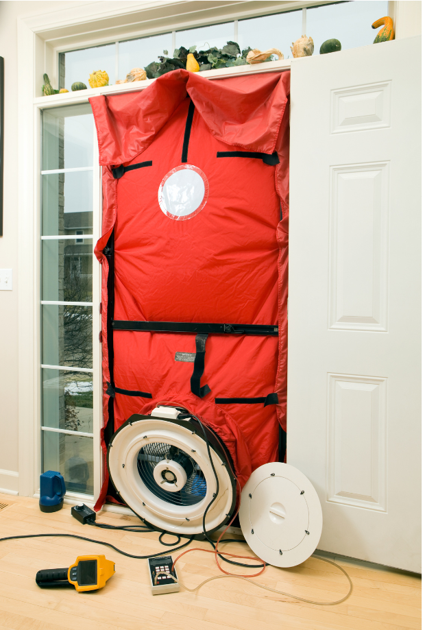 Red door blower test equipment in a doorway; fan blowing air.