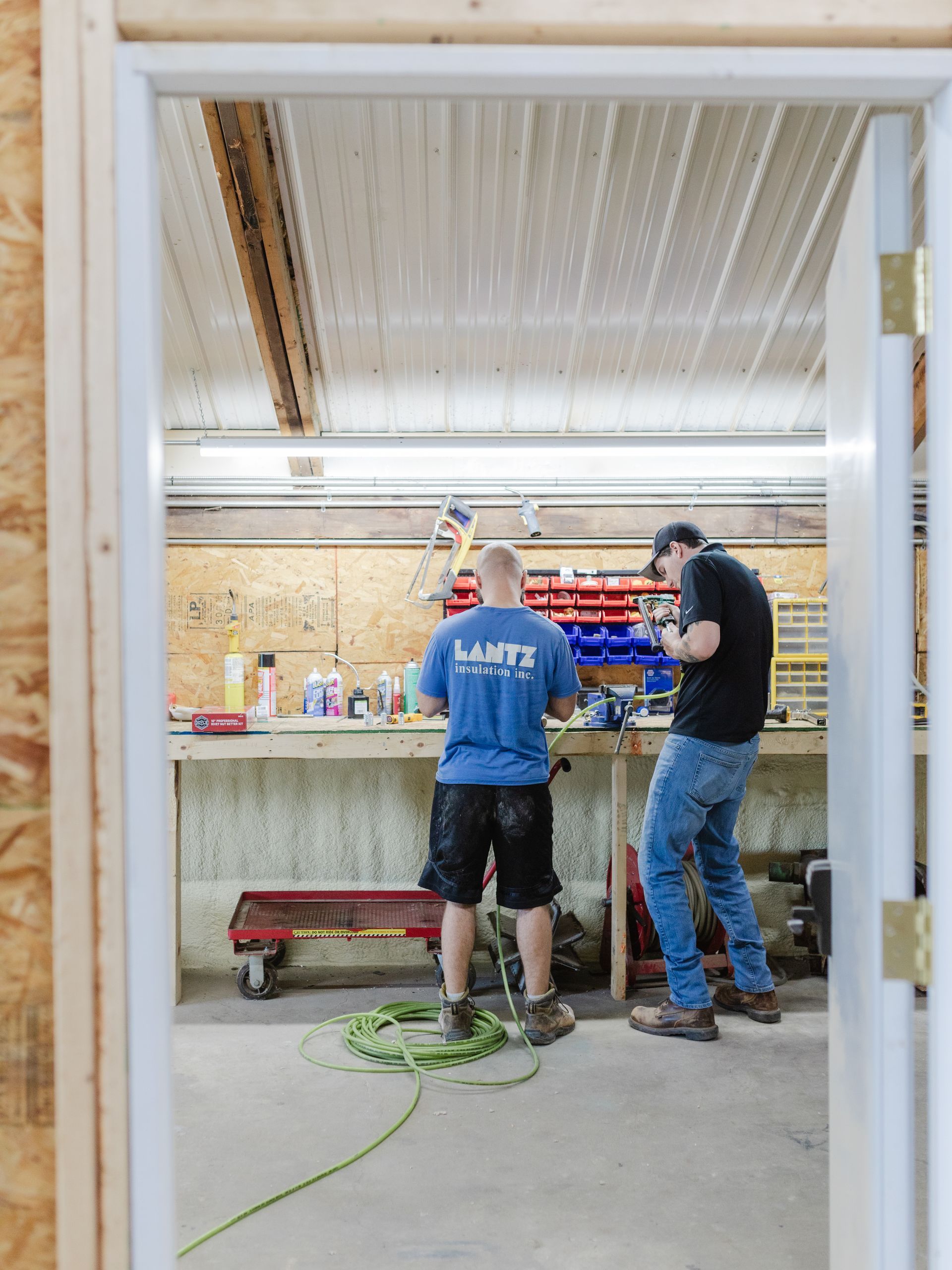 two men are working on a project in a garage .