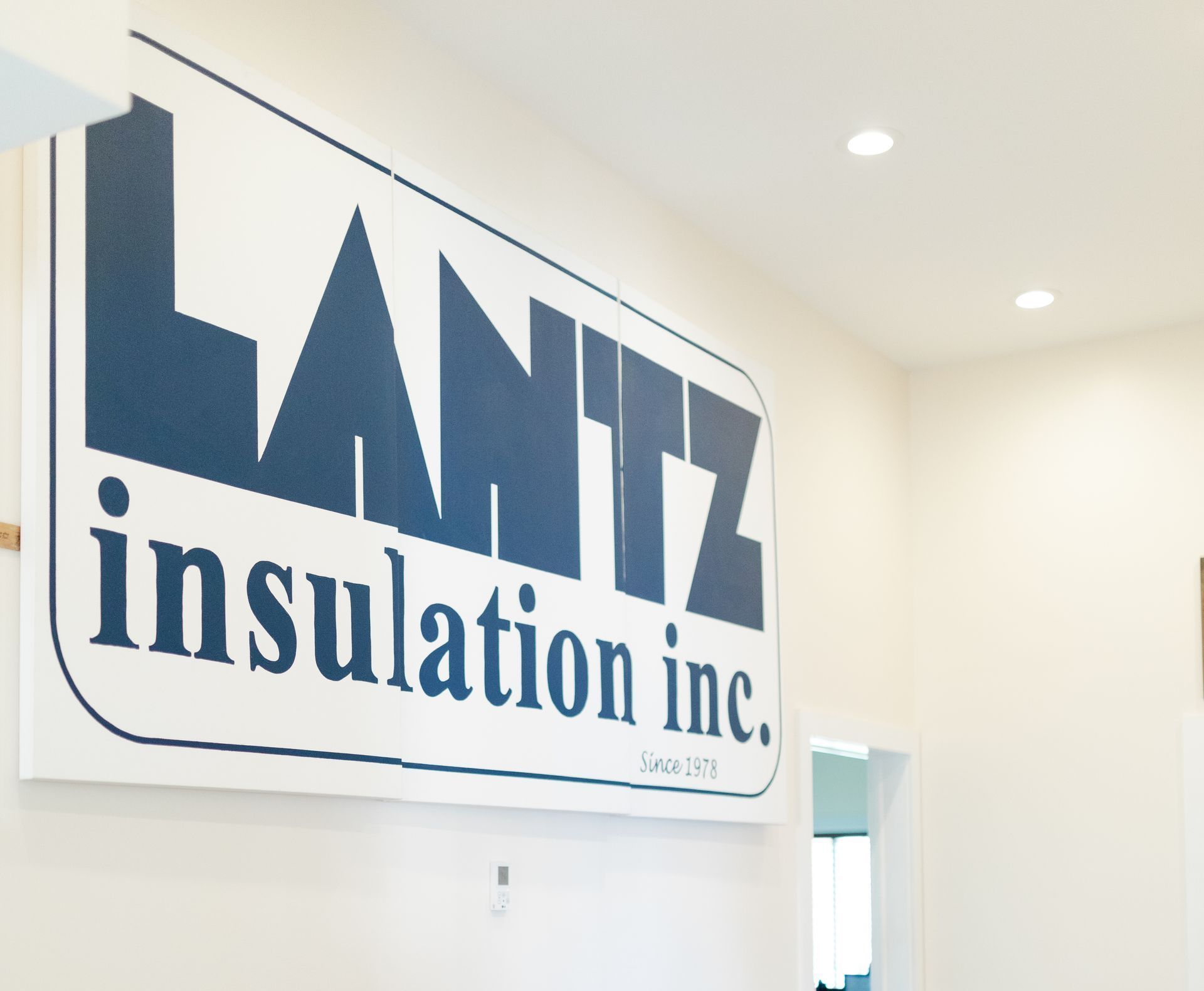 A sign for lantz insulation inc. hangs from the ceiling