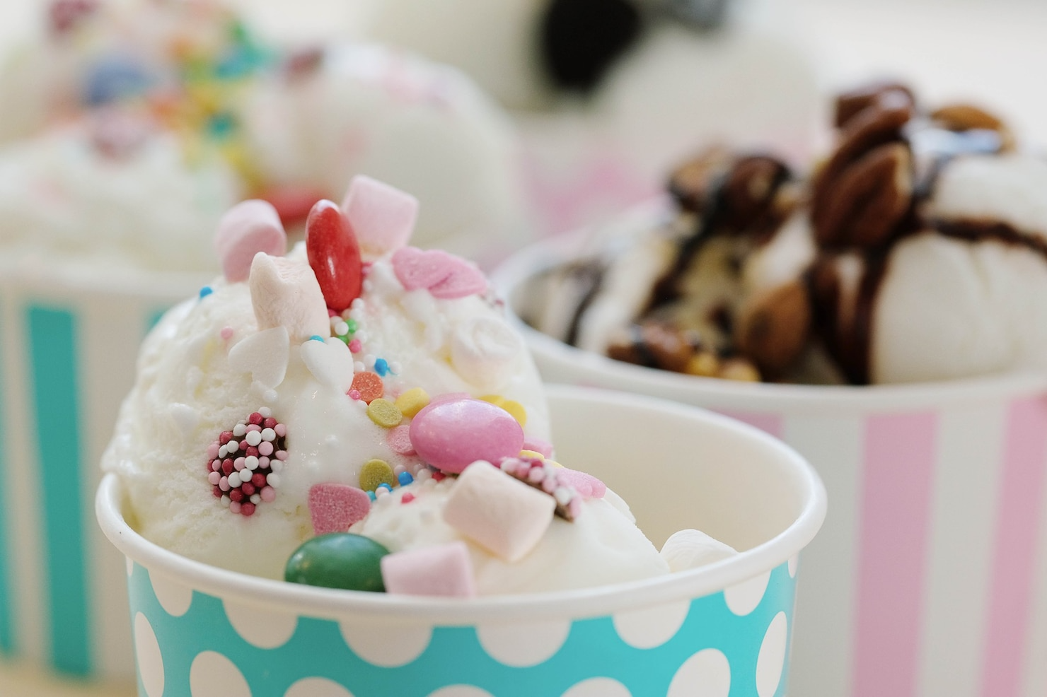 A cup of ice cream with marshmallows and sprinkles on top.