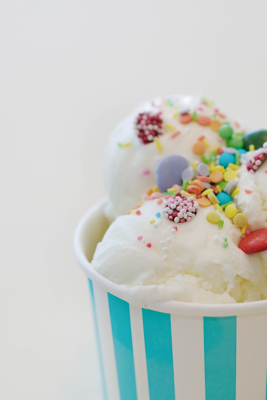 A cup of ice cream with sprinkles on top of it.