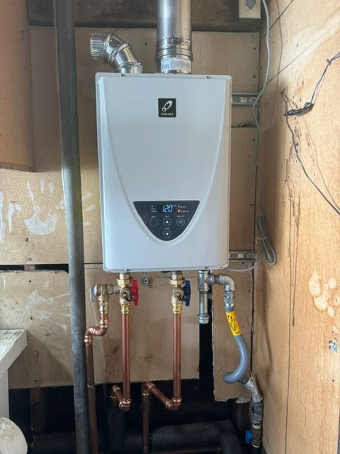 A white water heater with copper pipes attached to it