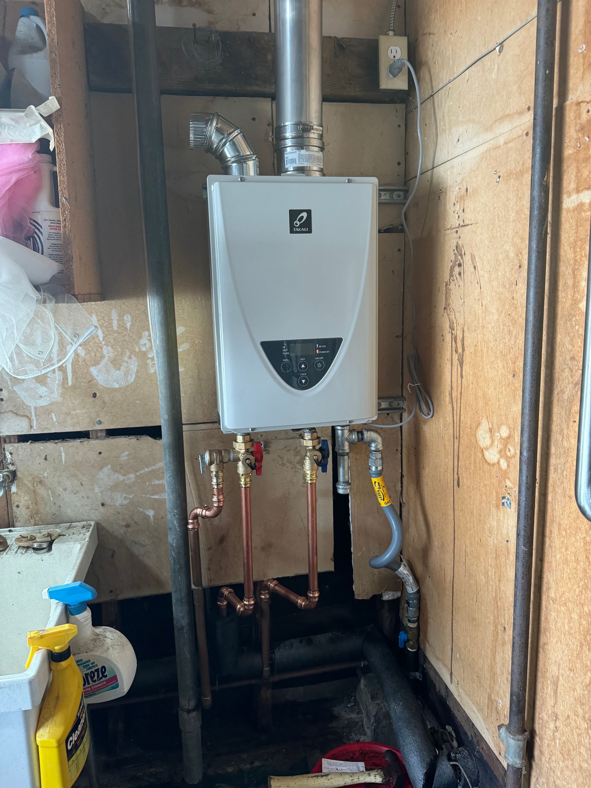 A water heater is installed in a bathroom next to a sink.