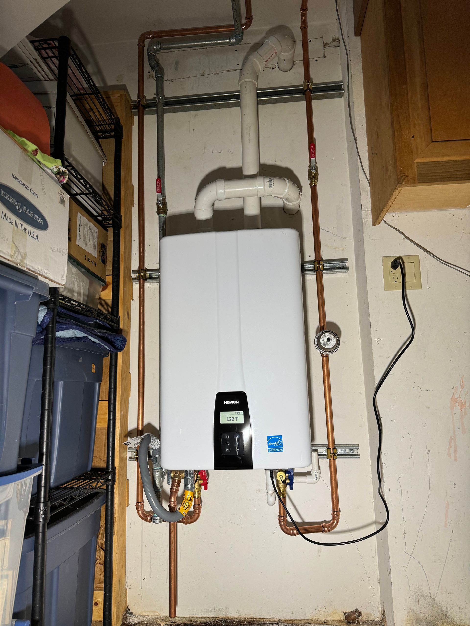 A water heater is mounted to a wall in a garage