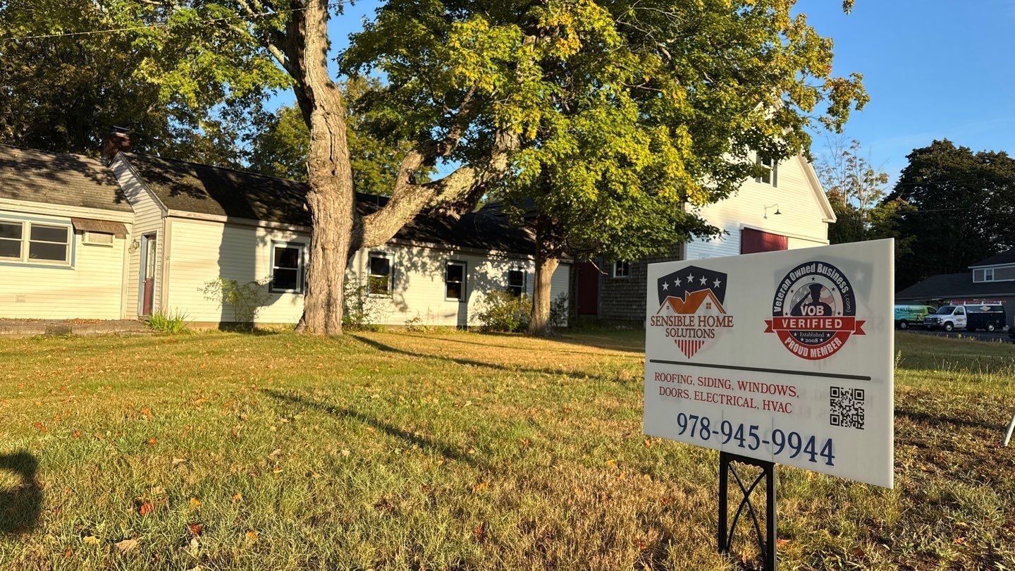 Sign in front of weathered building, lawn. Phone number and QR code on the sign.