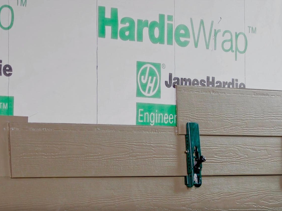 HardieWrap weather barrier with light brown siding, secured by a green clamp.