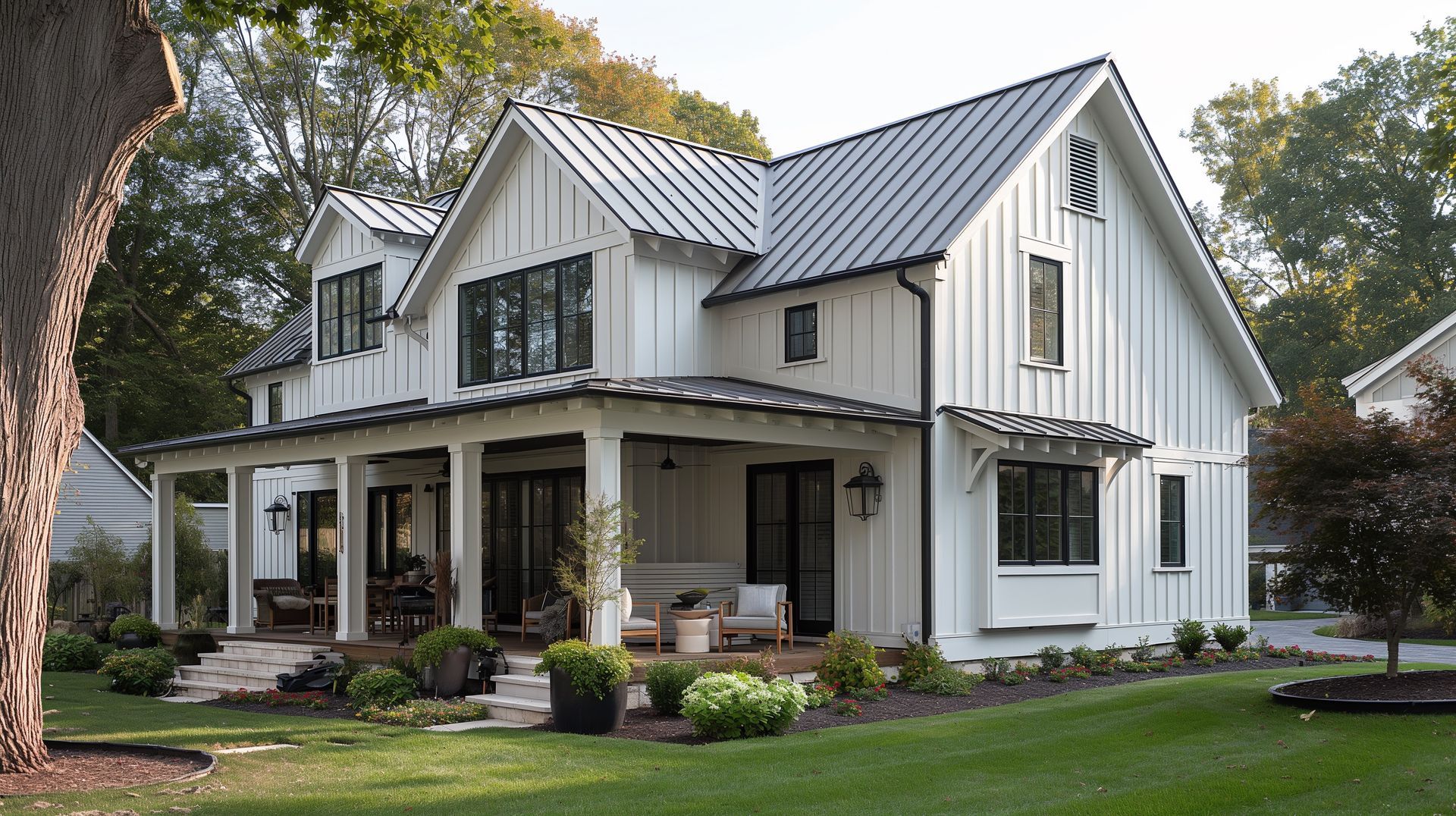 White farmhouse with black trim, a porch, and a metal roof.