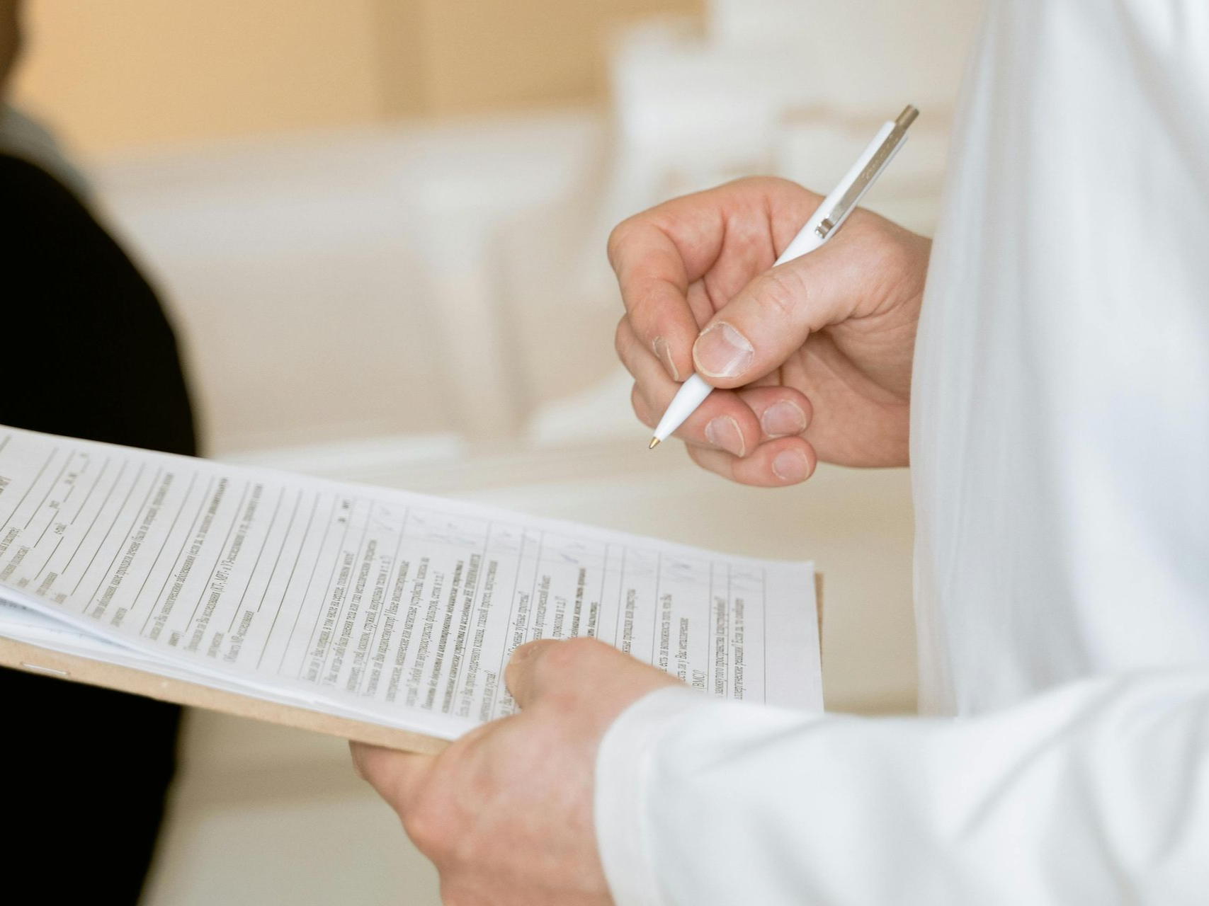 inspector writing on clipboard; patient in background.