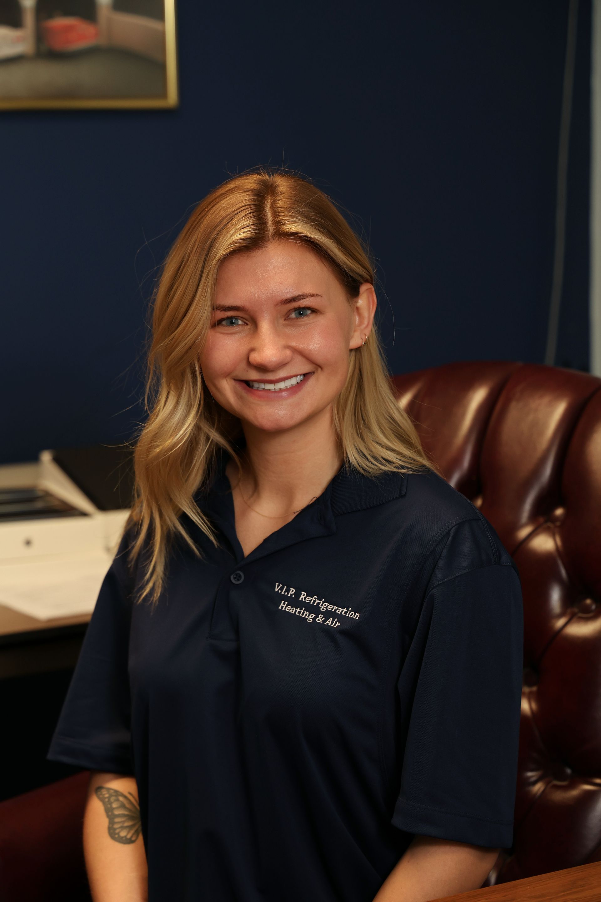 Technician in safety gear using laptop, inspecting large industrial equipment outdoors.