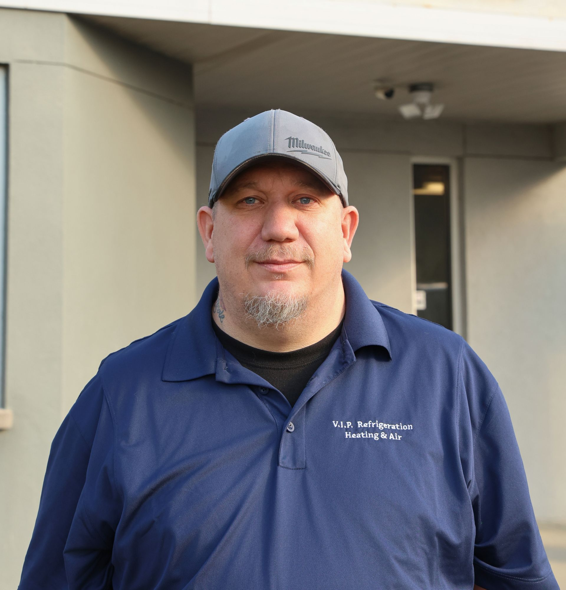 HVAC technician using gauges on an outdoor air conditioning unit.