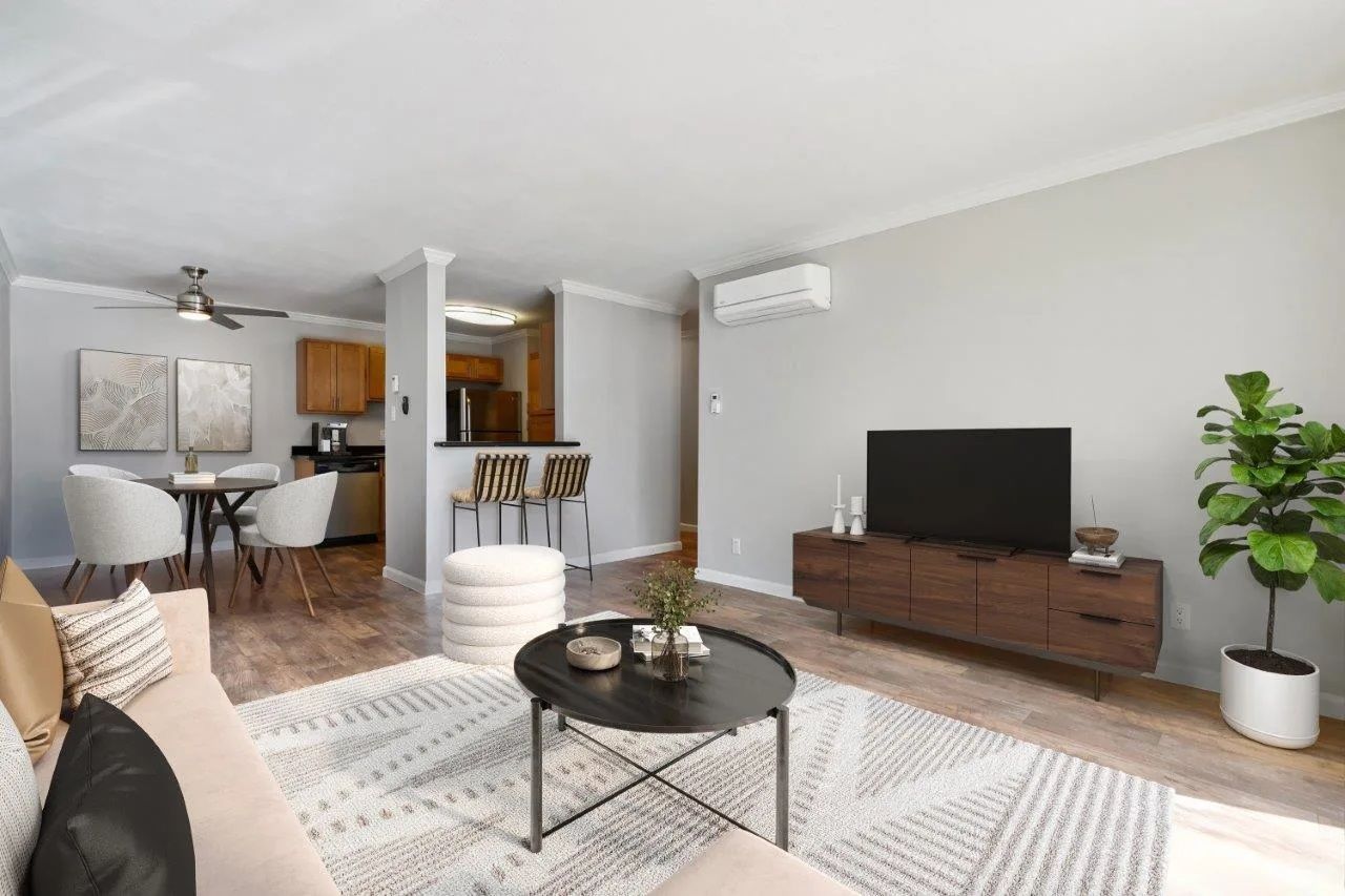 Living room with light gray walls, wood floors, and a brown TV console.