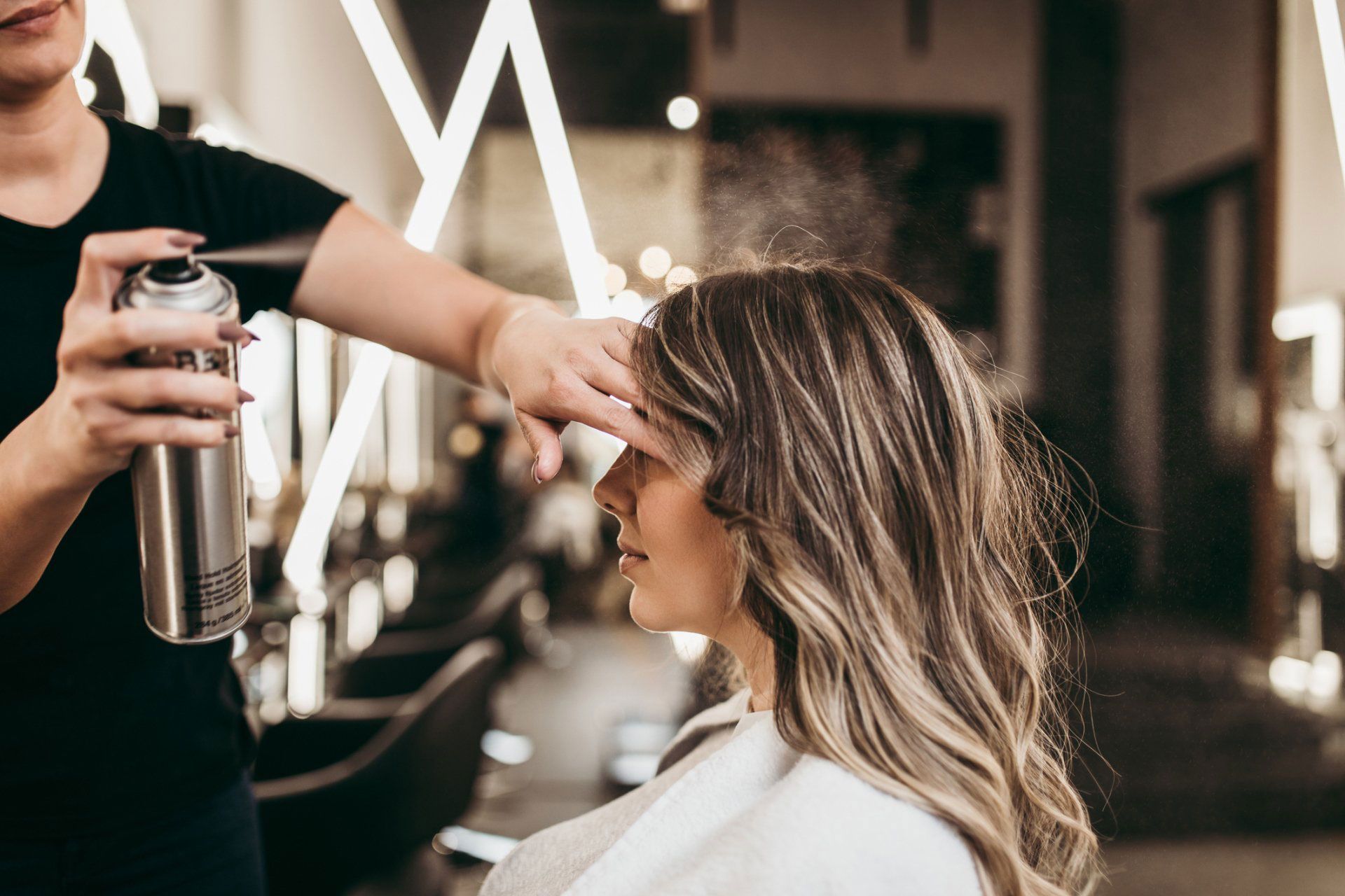 A woman is getting her hair done by a hairdresser.