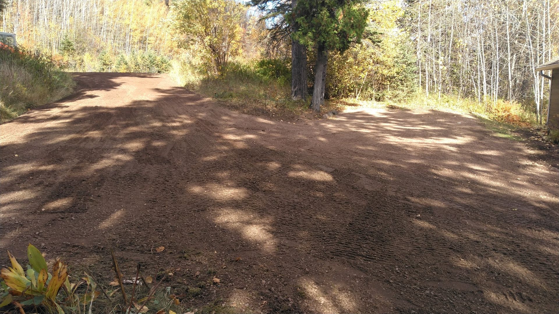 An excavator is digging a hole in the dirt next to a pipe.