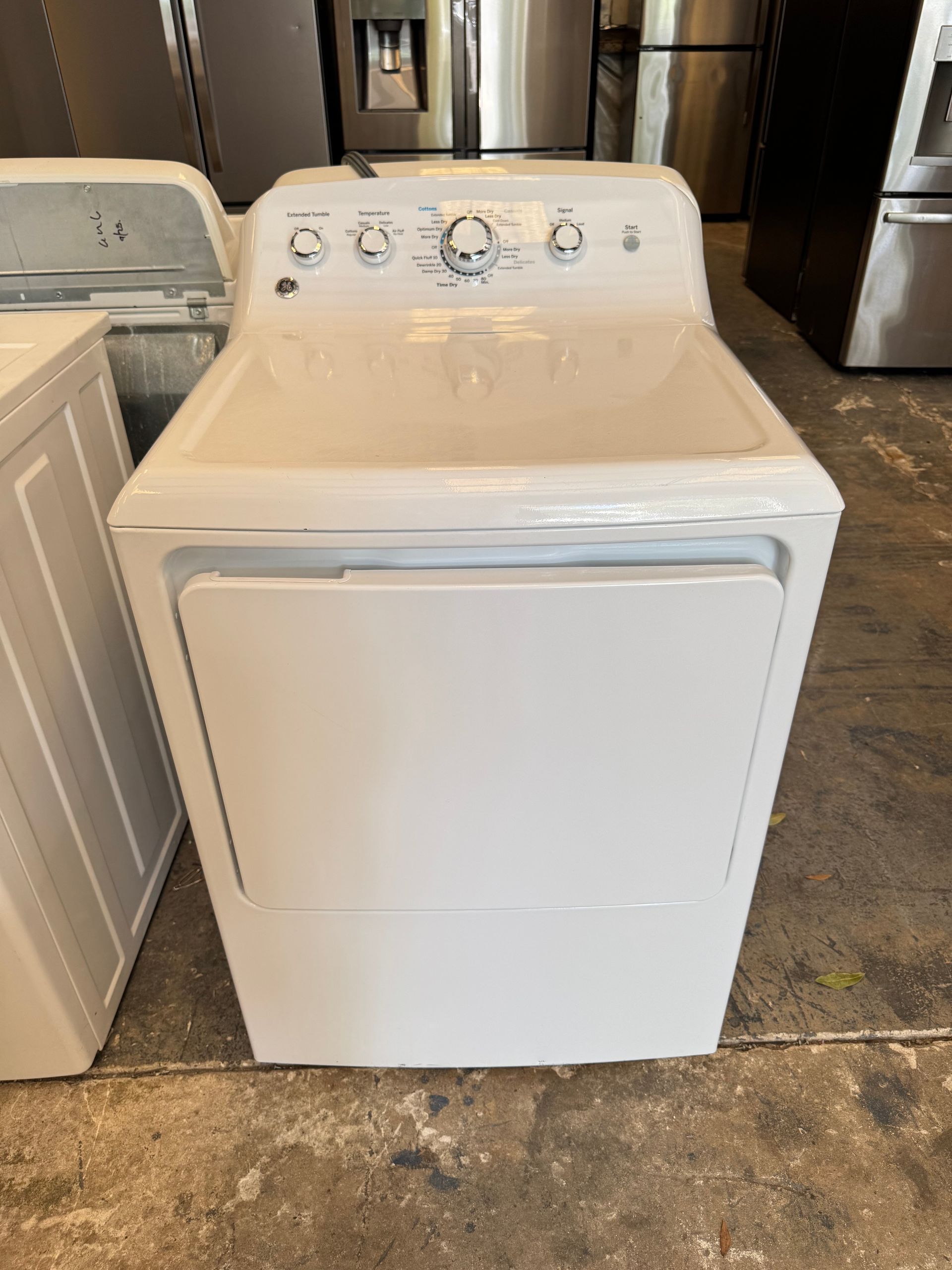 A white GE clothes dryer with a control panel on top, the door is closed.