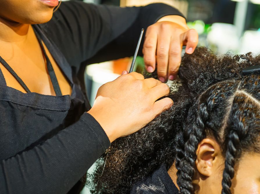 A woman is cutting a woman's hair in a salon