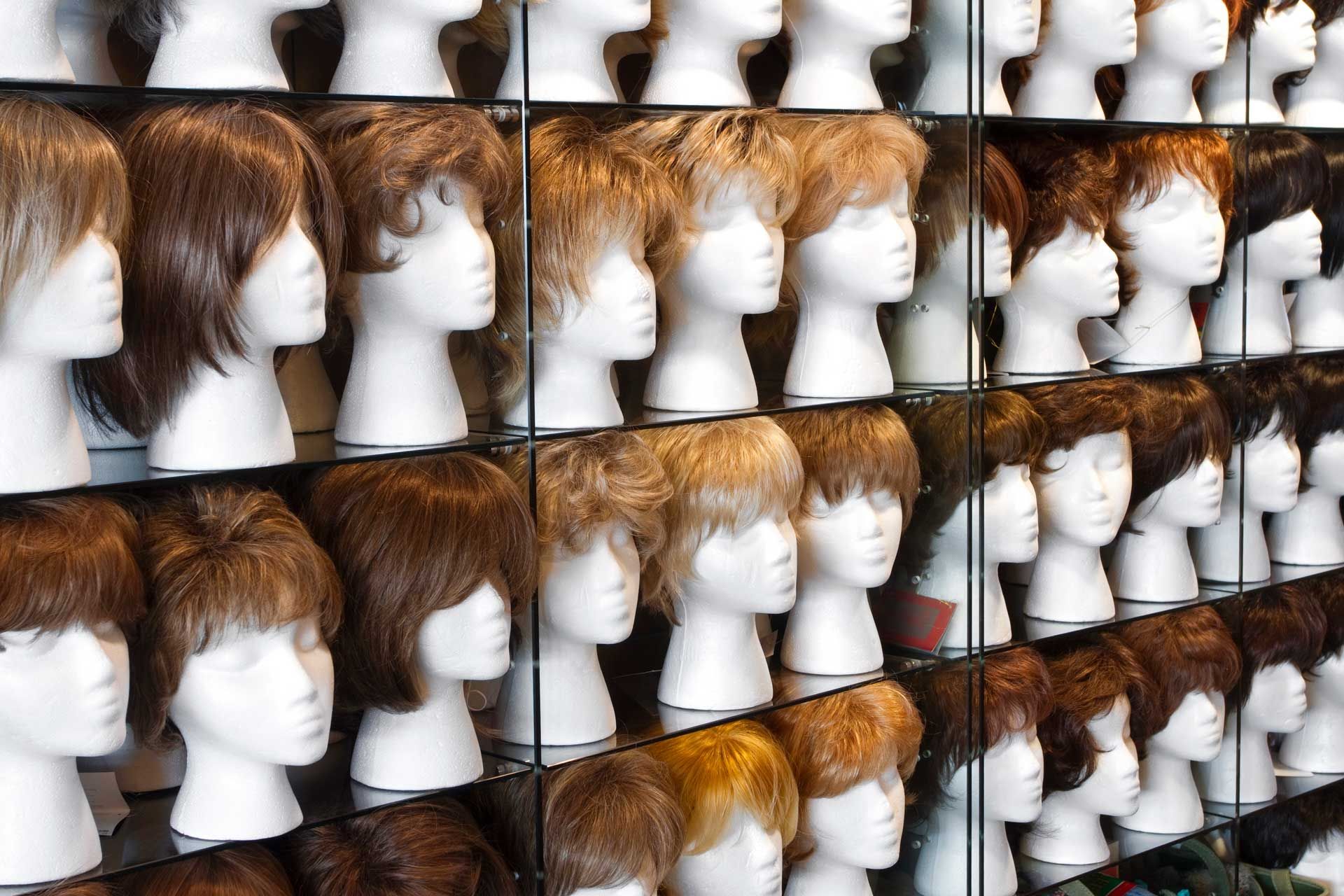 A row of mannequin heads with wigs on them