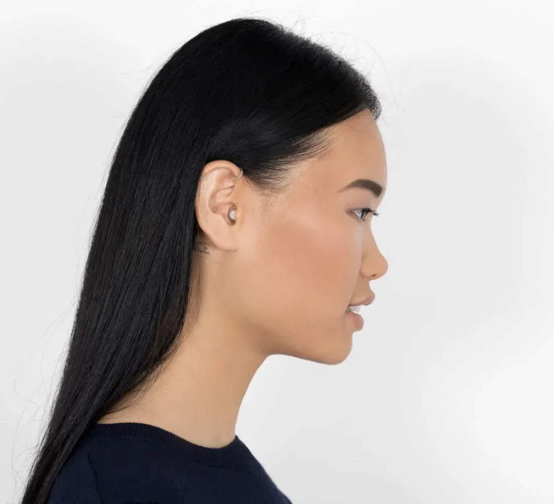 Woman with long black hair in profile, facing right, against a white background.