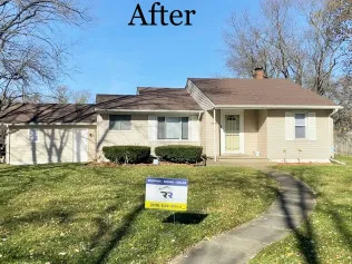 A house with a for sale sign in front of it.