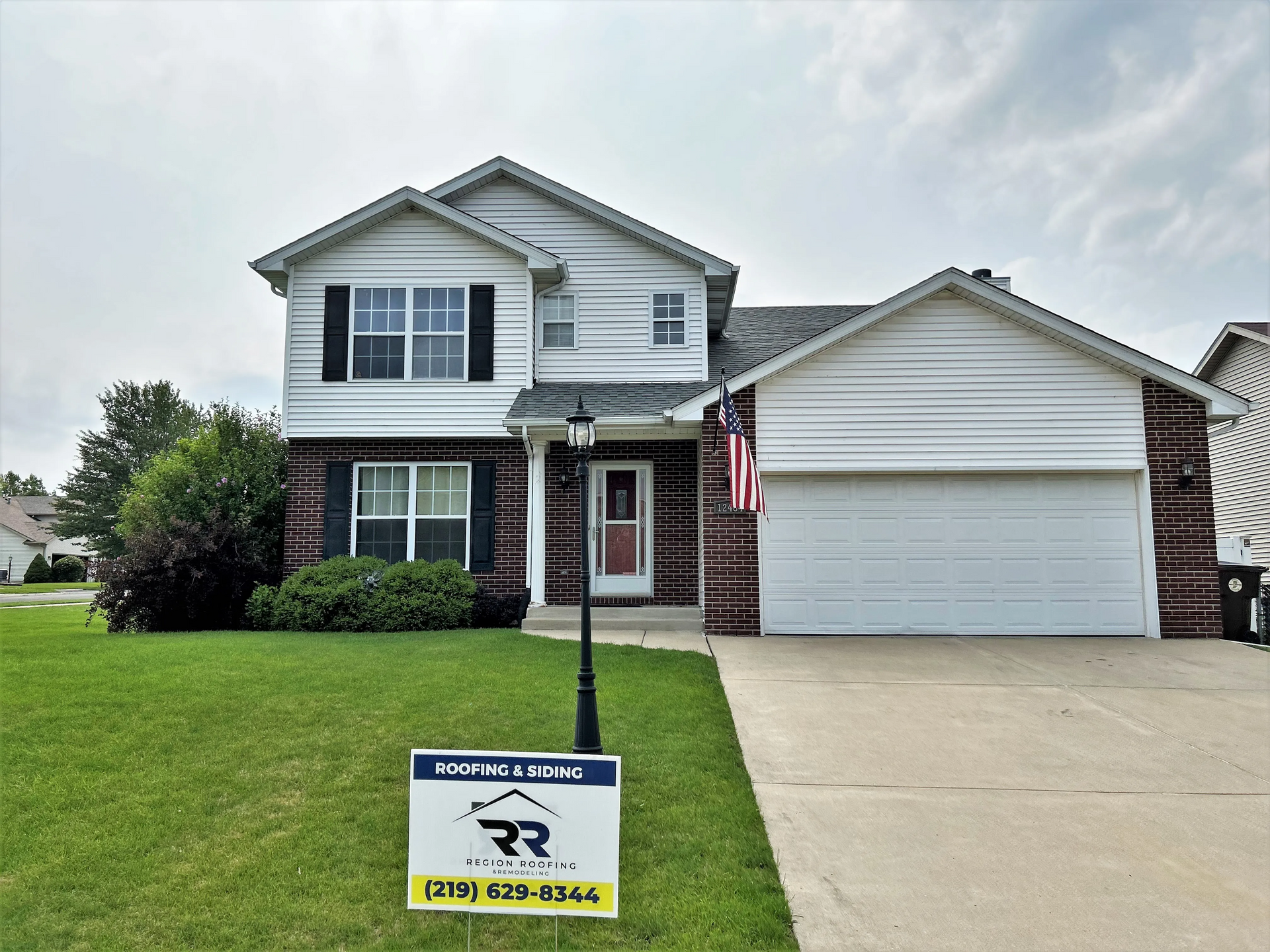 A house with a for sale sign in front of it.