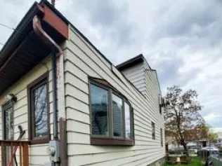 A house with a lot of windows and a gutter on the side of it.