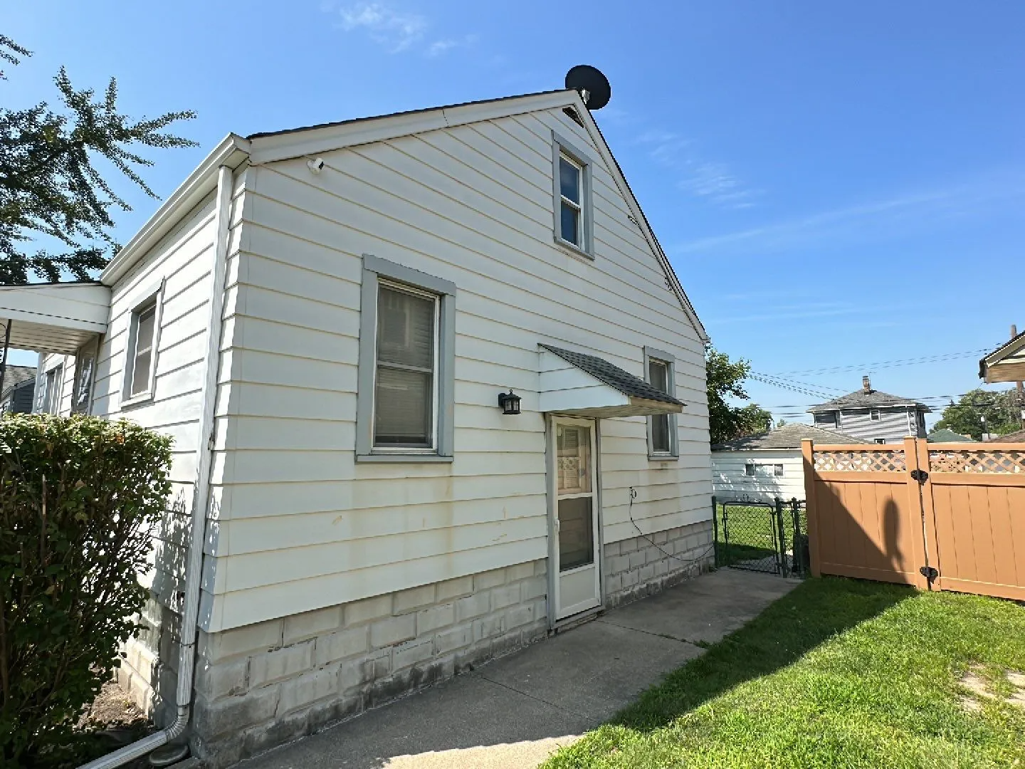A white house with a satellite dish on top of it