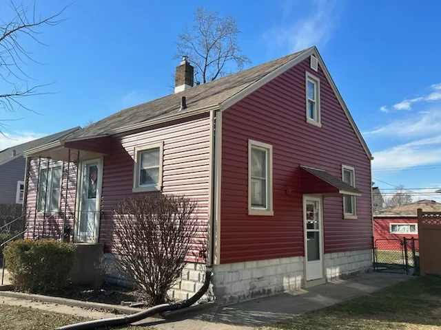 A red house with white siding and a white door