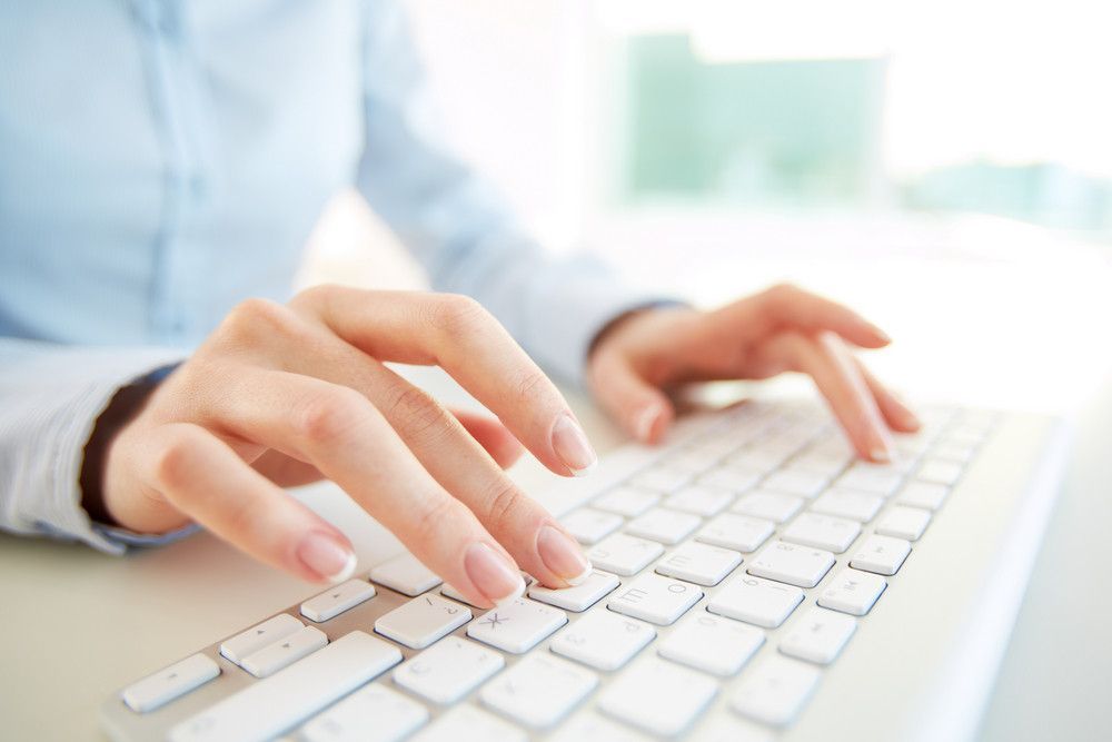 closeup of hands typing on a white keyboard - Wollongong Strata
