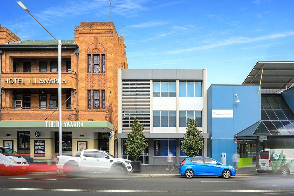 Street view with buildings, cars, and people. The Hotel Junibar is on the left. A modern building.
