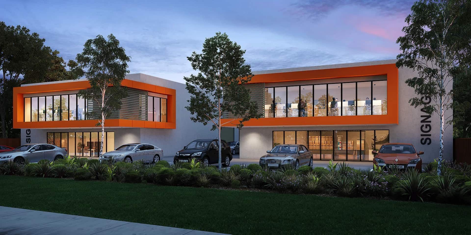 Modern office building with orange trim, parked cars, and landscaping.