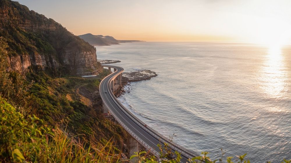 White apartment building with multiple balconies against a blue sky.
